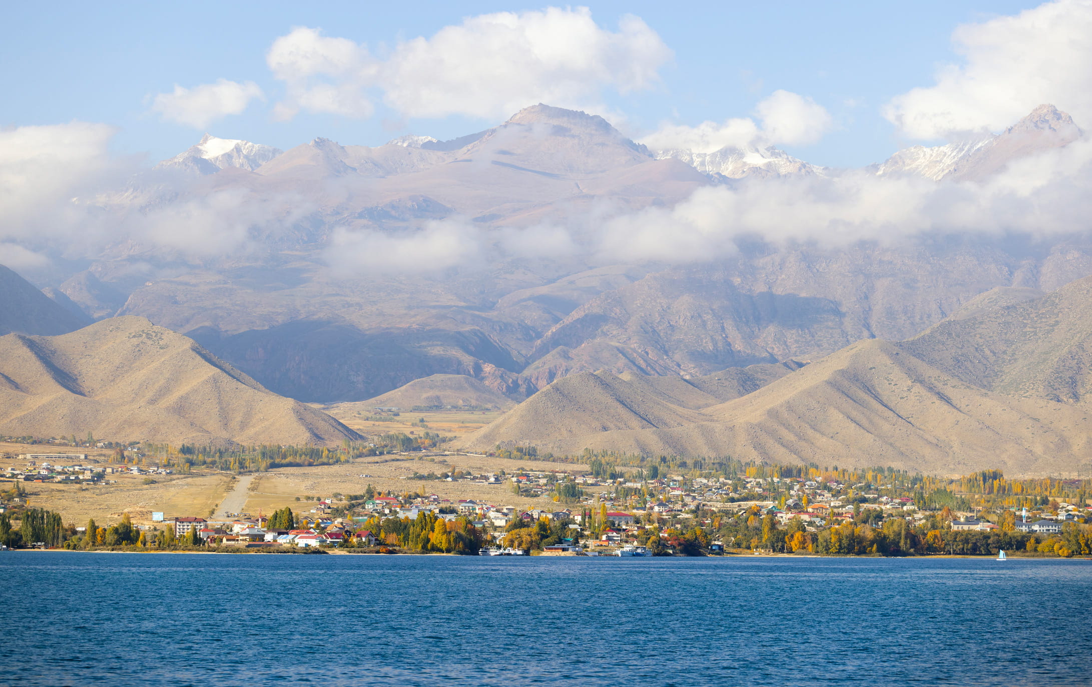 Natural Issyk Kul Lakeside And Town View In Kyrgzstan With Tian Shan Mountain Range