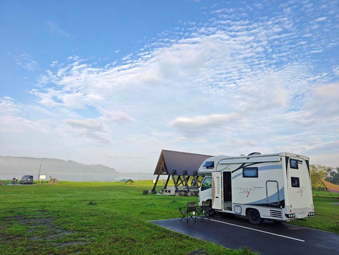 Camping by the lake with a Japan campervan under clear skies