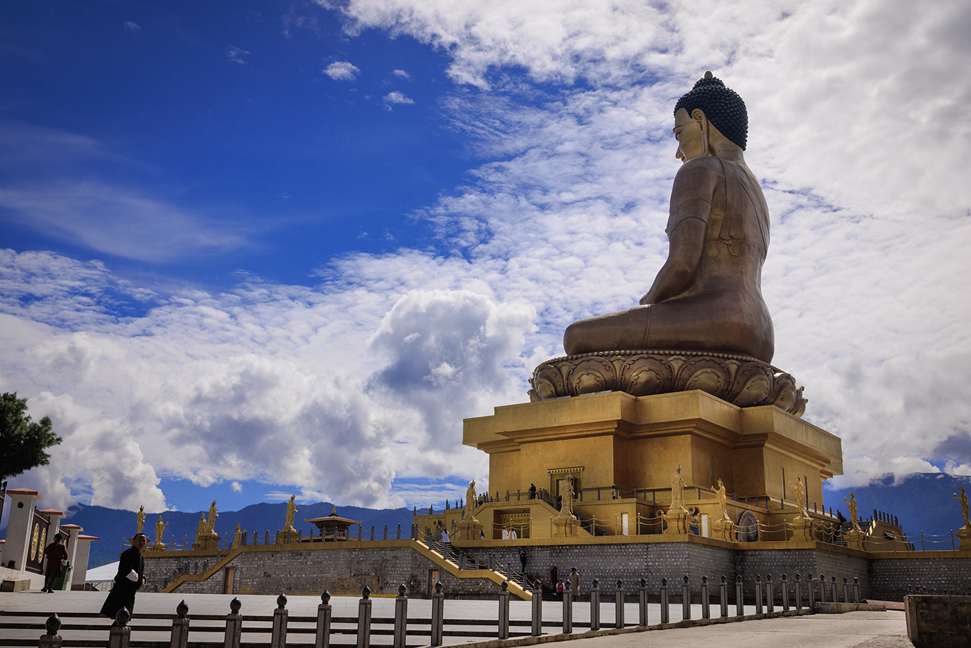 Golden Buddha Dordenma statue overlooking Thimphu Valley, Bhutan, with blue sky and clouds.