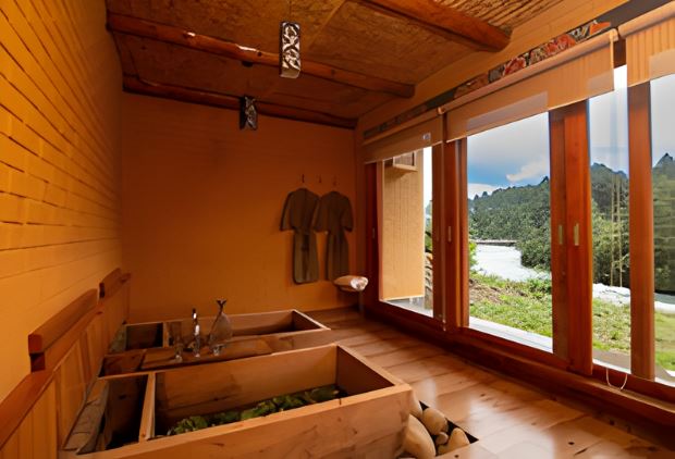 Private hot stone bath at Zanta Spa, Bhutan, with wooden interiors and large windows overlooking greenery