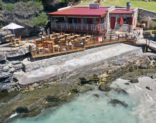 Exterior view of Perlemoen Restaurant in South Africa, showing outdoor seating and surroundings