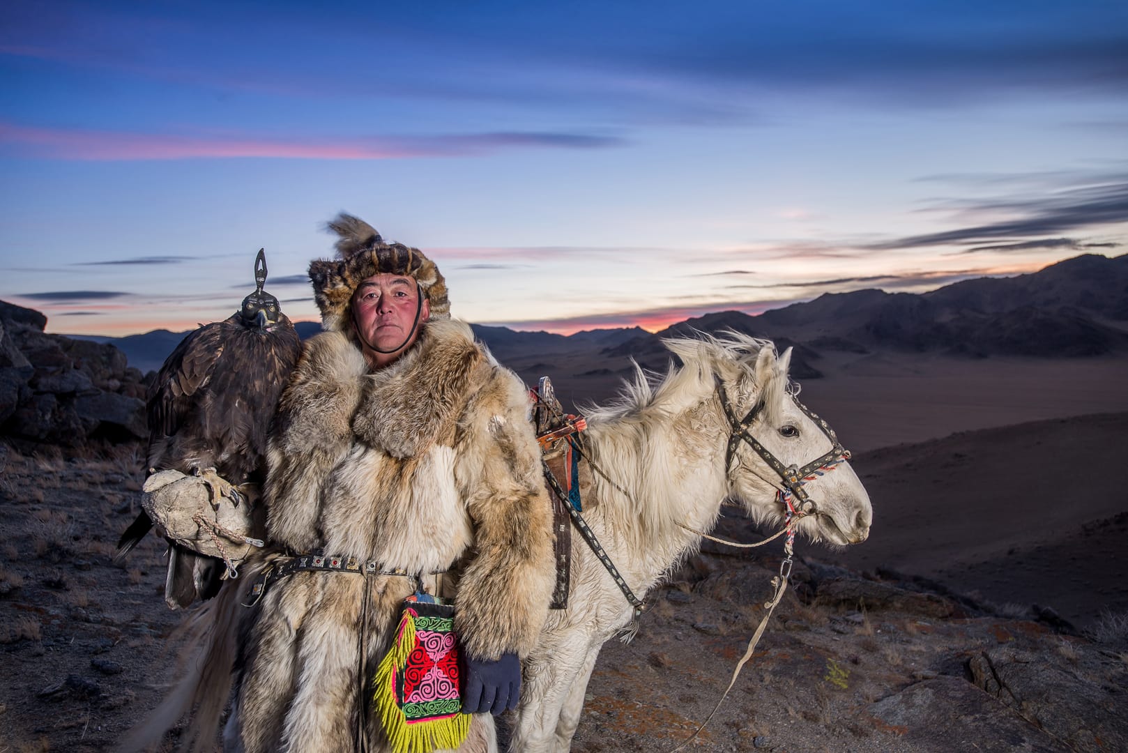 Altai Mountains Surrounding Eagle Hunters In Cold Autumn Conditions